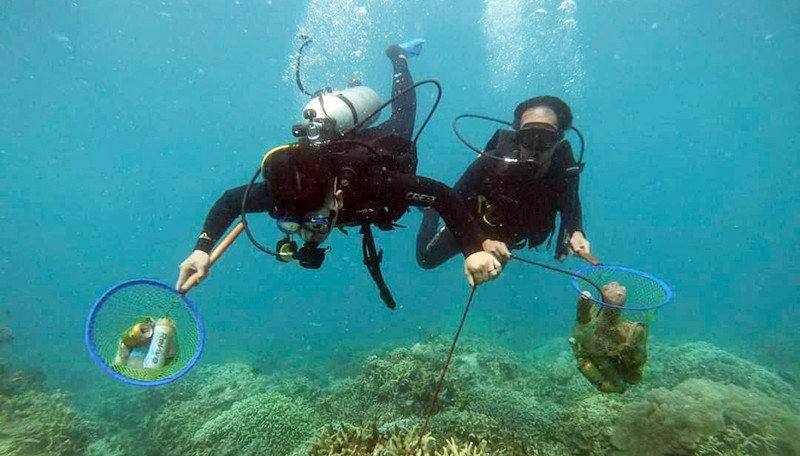 Divers collect rubbish in Hon Mun Marine Protected Area.