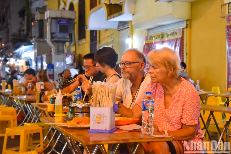 Foreign tourists enjoy local delicacies at Ta Hien Street.