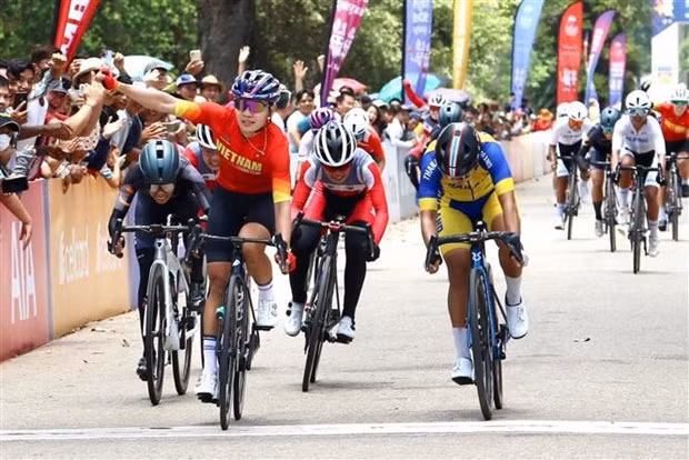 Asian champion Nguyen Thi That (red) triumphed in the women's road race mass star event. (Photo: VNA)