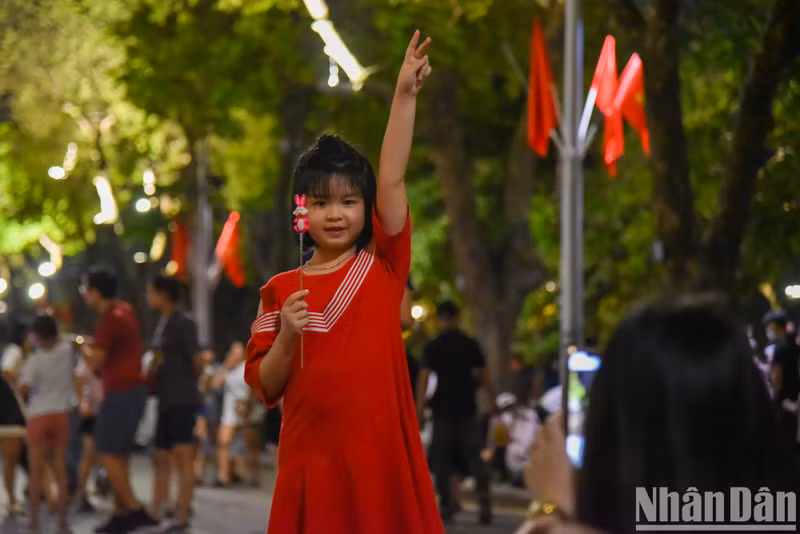 A girl poses for a photo taken by her mother.