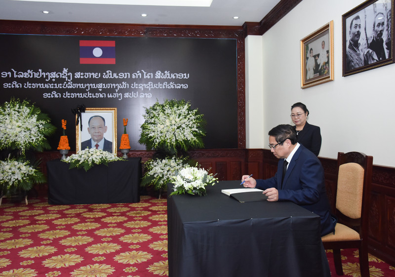 PM Pham Minh Chinh writes in the condolence book at the Lao Embassy in Vietnam. (Photo: Tran Hai)