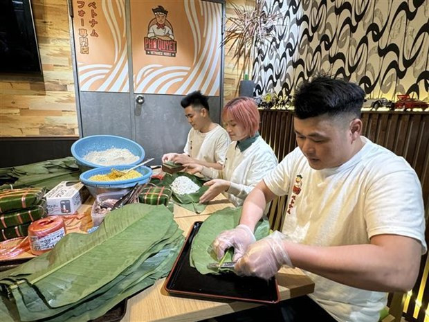Staff at Quyet "Pho" restaurant in Tokyo make "chung" cakes. (Photo: VNA)
