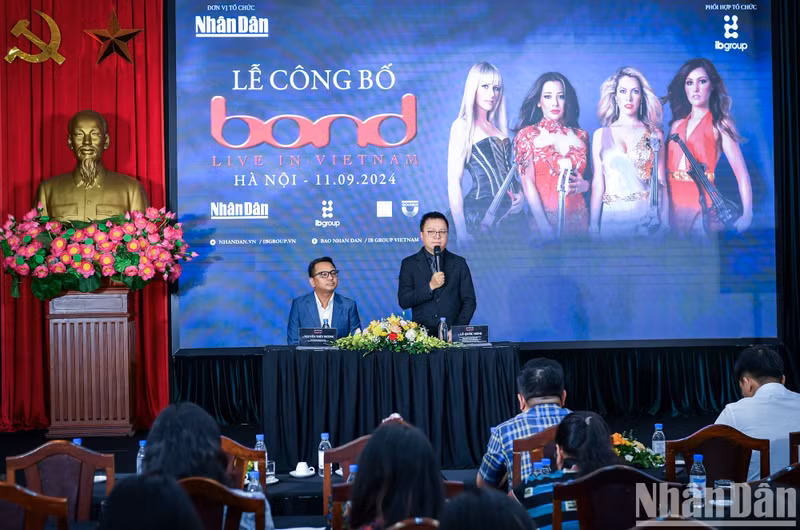 Nhan Dan's Editor-in-chief Le Quoc Minh speaks at an event to announce BOND's performance in Vietnam.