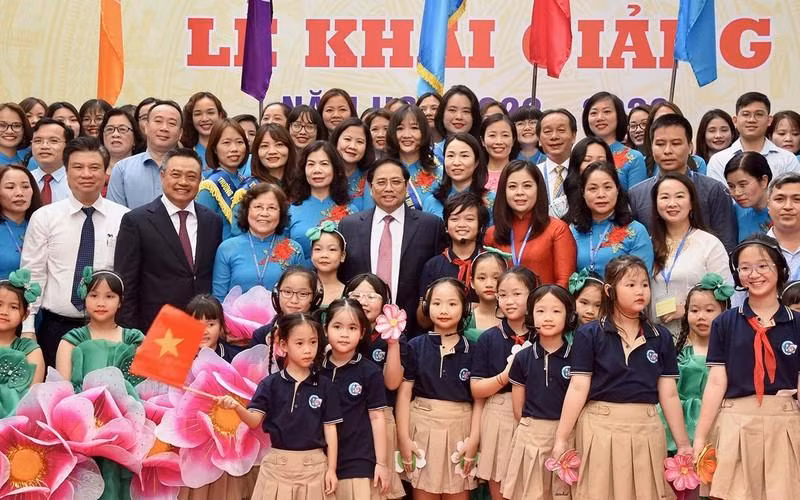 Prime Minister Pham Minh Chinh and students and teachers of Doan Thi Diem Primary School in Hanoi. (Photo: Tran Hai)
