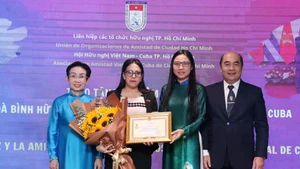 Cuban Consul General in Ho Chi Minh City Ariadne Feo Labrada (second, left) receives the “For peace and friendship among nations” insignia of the Viet Nam Union of Friendship Organisations at the event (Photo: VNA)