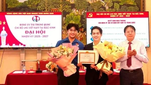 Nguyen Hong Phuc (left) receives an award at the Political Theory Writing Contest on Protecting the Party’s Ideological Foundations organised by the Ministry of Foreign Affairs. (Photo courtesy of the interviewee)