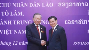 General Secretary of the Central Committee of the Lao People's Revolutionary Party and President of Laos Thongloun Sisoulith (right) congratulates General Secretary of the Central Committee of the Communist Party of Viet Nam To Lam on receiving the National Gold Medal - the highest honour of Laos (Photo: VNA)