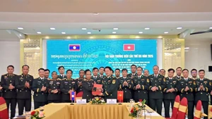 The two sides sign the minutes of the meeting. (Photo: VNA)