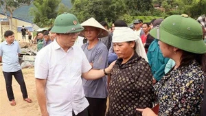 Deputy PM Le Thanh Long offers encouragement to families affected by floods and landslides. (Photo: VNA) 