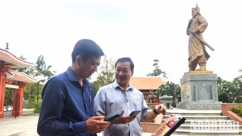 Mr Pham Van Minh, Deputy Director of Dong Nai Museum (on the right), introduces the NFC chip-enabled board at the Nguyen Huu Canh Temple Relic Site.