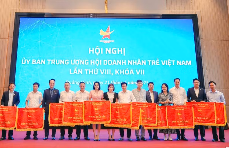 Dang Hong Anh, President of the Viet Nam Young Entrepreneurs Association, (third from left) presents emulation flags to representatives of associations nationwide.