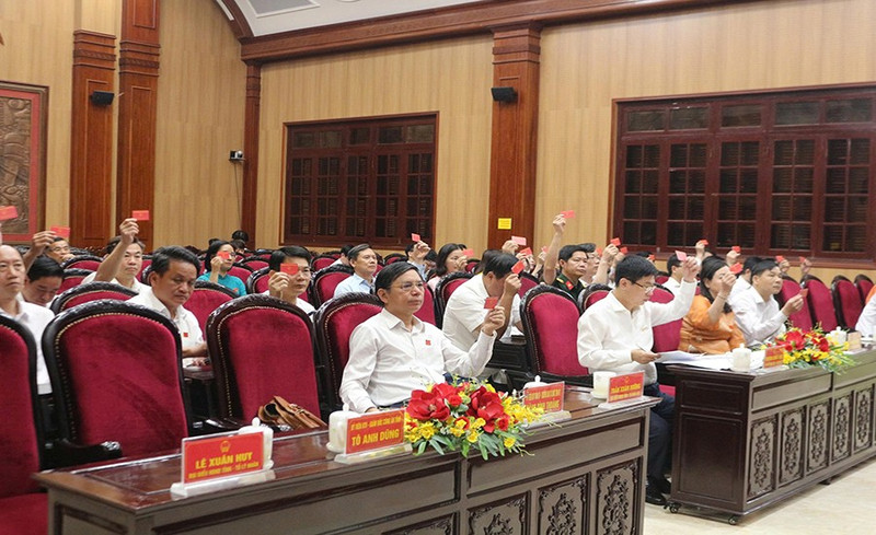 Delegates of the Ha Nam Provincial People’s Council vote to pass resolutions at the session.