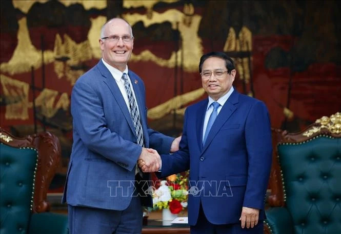 Prime Minister Pham Minh Chinh (R) and John Moolenaar, Congressman of Michigan state, heead of the US House of Representatives’ bipartisan delegation. (Photo: VNA)