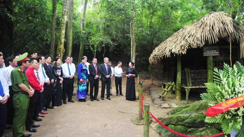 Cadres involved in mass mobilisation work in Tuyen Quang Province report their achievements to Uncle Ho at Na Nua Shack.