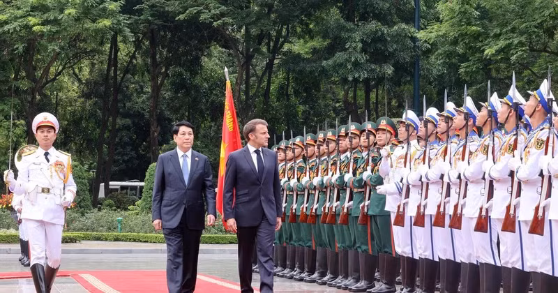 State President Luong Cuong (left) and French President Emmanuel Macron review the Guard of Honour of the Viet Nam People’s Army. (Photo: VNA)