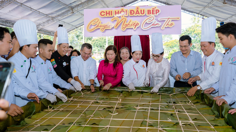 Can Tho City officials and local artisans posed next to the giant sticky rice cake at the festival.