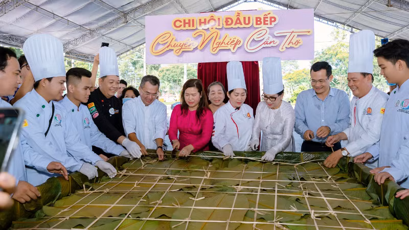 Can Tho City officials and local artisans posed next to the giant sticky rice cake at the festival.