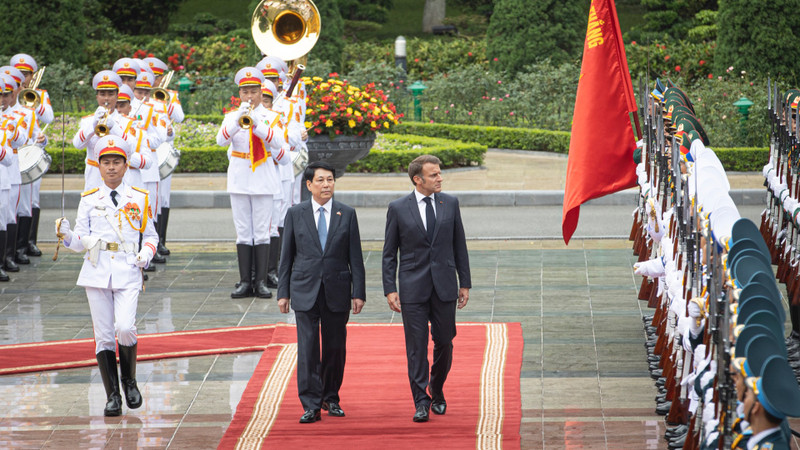 State President Luong Cuong and French President Emmanuel Macron inspect the Guard of Honour of the Viet Nam People's Army