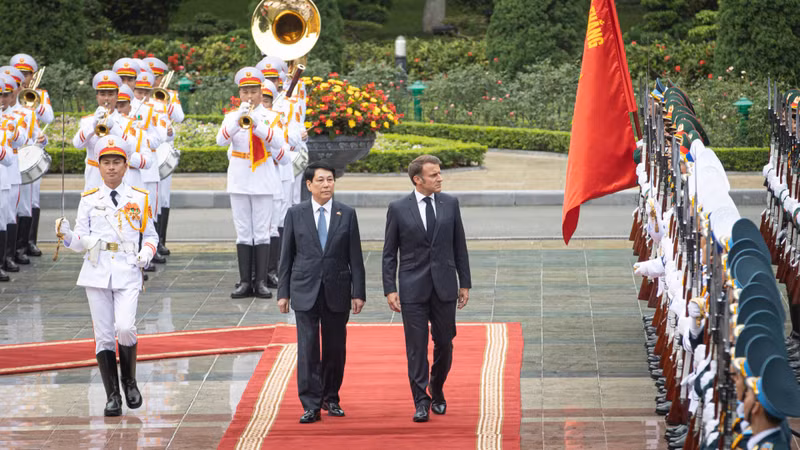 State President Luong Cuong and French President Emmanuel Macron inspect the Guard of Honour of the Viet Nam People's Army
