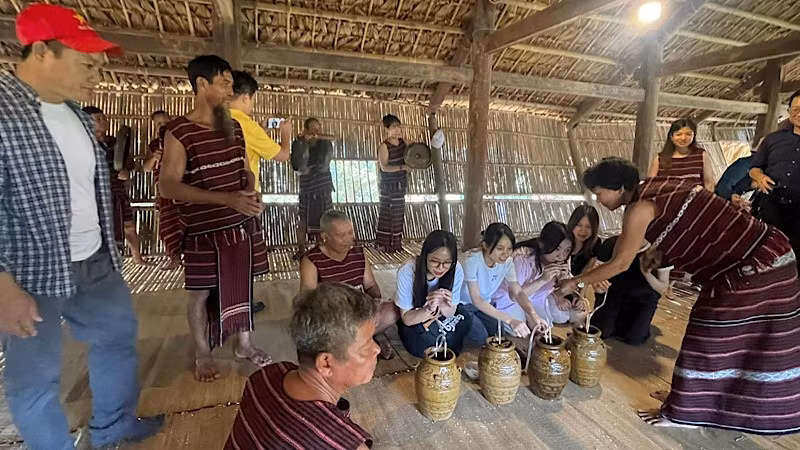 Visitors experience drinking rice wine with the ethnic groups.