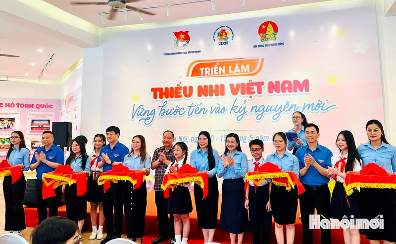 Delegates and children from the capital cut the ribbon to open the exhibition. (Photo: HNMO)