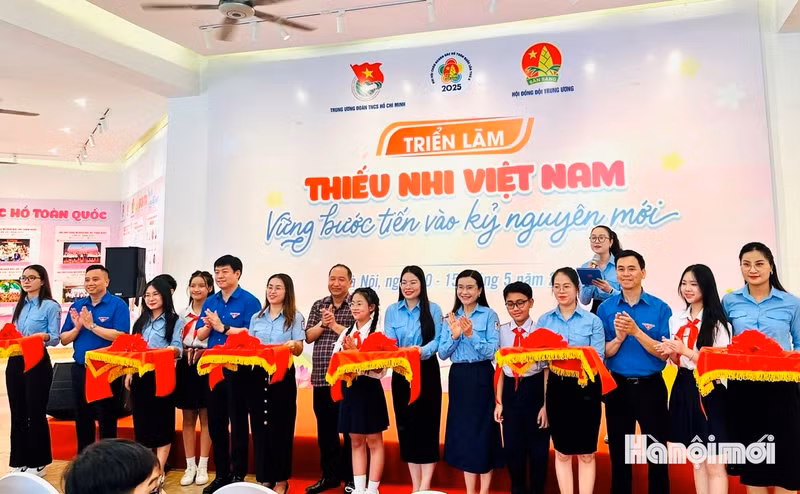 Delegates and children from the capital cut the ribbon to open the exhibition. (Photo: HNMO)
