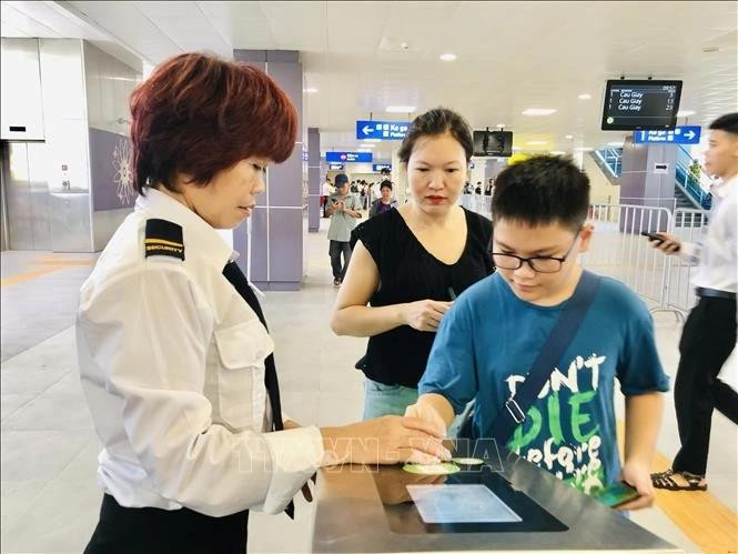 Ha Noi Metro staff assist passengers at the ticket gate. (Photo: VNA)