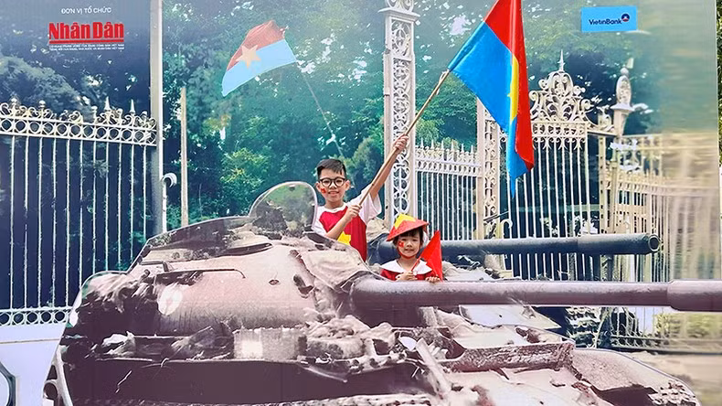 Brothers Minh Nhat and Nhat Anh capture memories at the exhibition. (Photo: NDO)