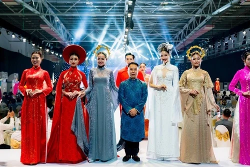 Designer Nguyen Viet Hung and models present a collection of traditional ao dai for Vietnamese women, created using Thai Tuan fabric.