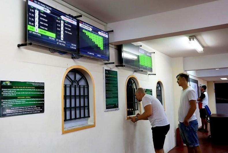 Foreign visitors place bets at the Vung Tau greyhound race track.