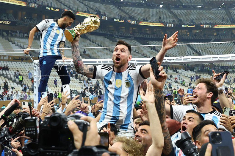 Argentina's Lionel Messi celebrates with the trophy and fans after winning the World Cup. (Photo: REUTERS/Kai Pfaffenbach)