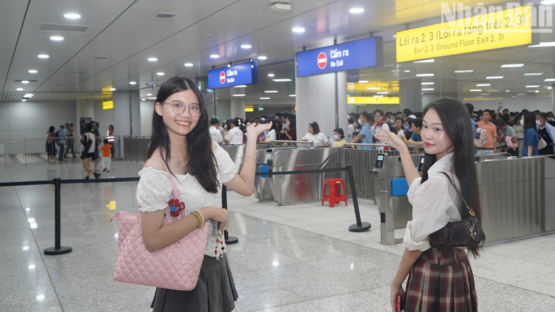 Young girls pose for photos inside a metro station.