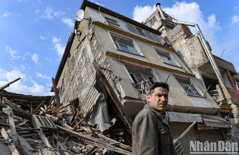 A man walks past his home, which was overturned by the earthquake on February 6. A man walks past his home, which was overturned by the earthquake on February 6.