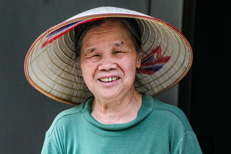 An old lady happily wears a hat after being perfected by her own hands. An old lady happily wears a hat after being perfected by her own hands.