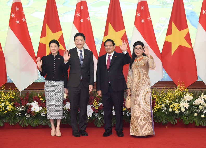 PM Pham Minh Chinh, Singaporean PM Lawrence Wong and their spouses pose for a photo.