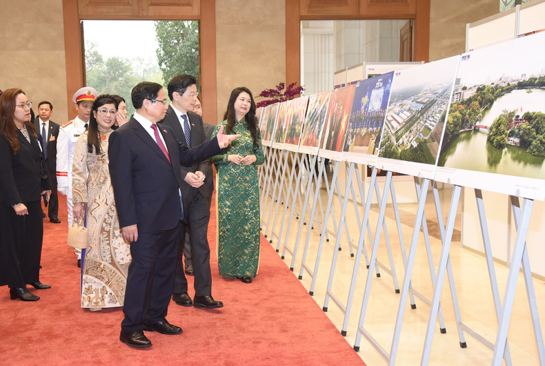 PM Pham Minh Chinh, Singaporean PM Lawrence Wong and their spouses visit a photo exhibition on cooperation between Vietnam and Singapore.