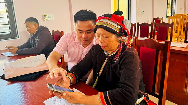 A VBSP official instructs people on how to use a mobile app to manage their policy credit. A VBSP official instructs people on how to use a mobile app to manage their policy credit.