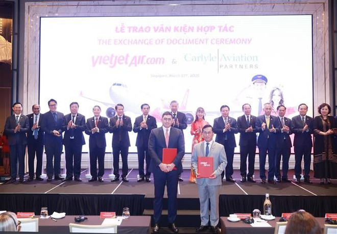 Party General Secretary To Lam and delegates witness the exchange of cooperation agreement between Vietjet Air and Carlyle Aviation Partners. (Photo: VNA)