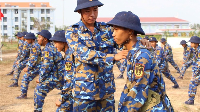 A commanding officer guides and corrects combat postures for new soldiers.
