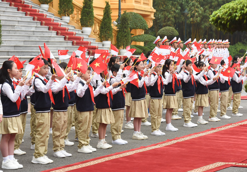 Children wave at the two prime ministers and their spouses.