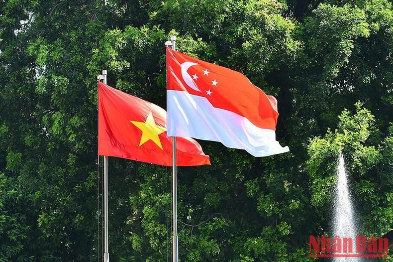 The national flags of Vietnam and Singapore are flying at the Presidential Palace.