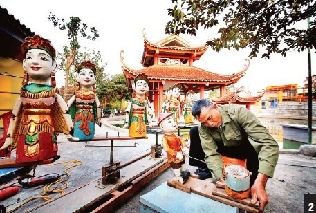 Artisan Nguyen Chat Luan is inspecting the puppet figures. Artisan Nguyen Chat Luan is inspecting the puppet figures.