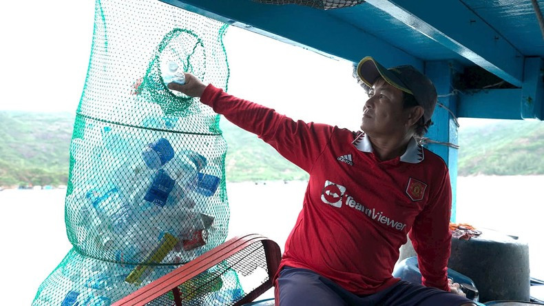 Fishermen sort rubbish on their boats.