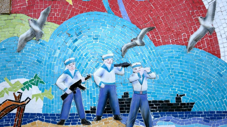 A ceramic mural of Navy soldiers and seagulls.