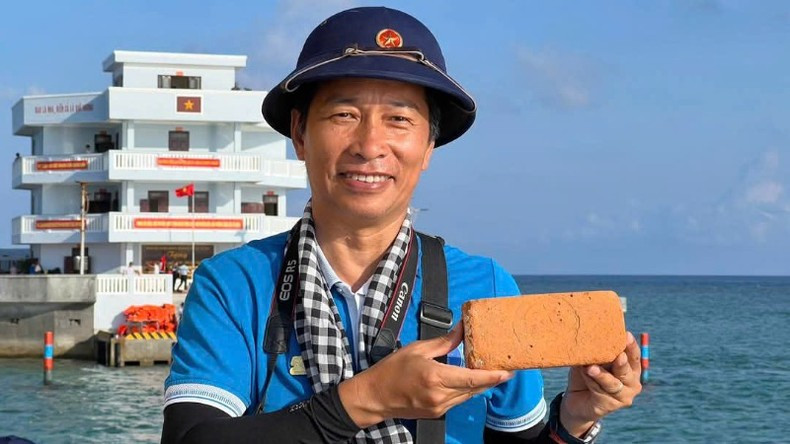 A visitor holds a brick for construction of structures in Truong Sa.
