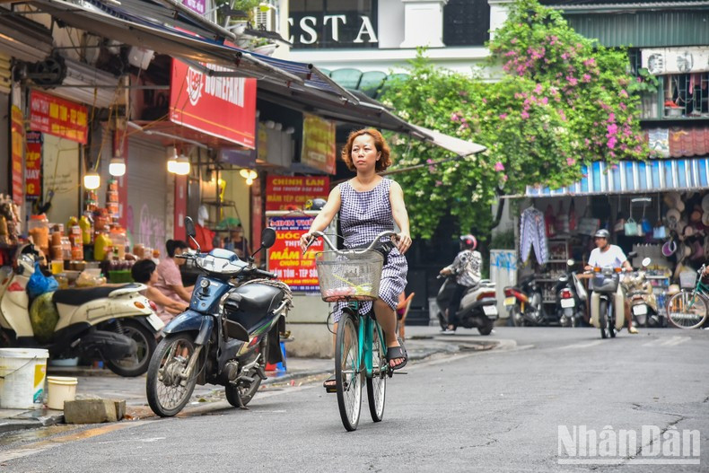 A Hanoi resident bikes to a market to shop for Doan Ngo Festival foods. A Hanoi resident bikes to a market to shop for Doan Ngo Festival foods.