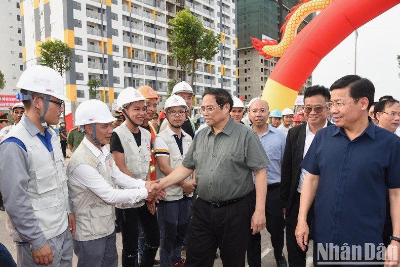 PM Pham Minh Chinh shakes hands with construction workers of the housing project. PM Pham Minh Chinh shakes hands with construction workers of the housing project.