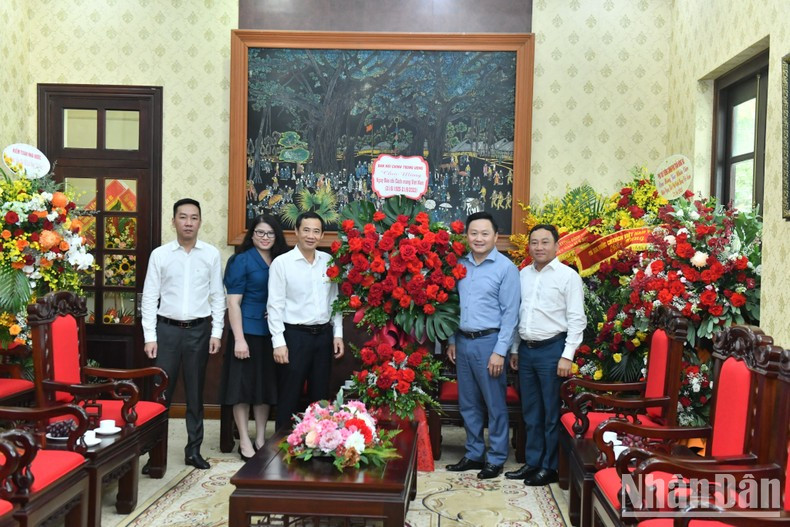 Deputy Head of the Central Commission for Internal Affairs Nguyen Thai Hoc presents flowers to Nhan Dan Newspaper on the occasion of Vietnam Revolutionary Press Day.