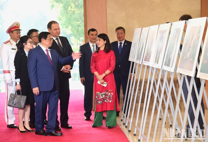 Prime Minister Pham Minh Chinh introduces photos of socio-economic cooperation between the two countries to his Belarusian counterpart Roman Golovchenko.