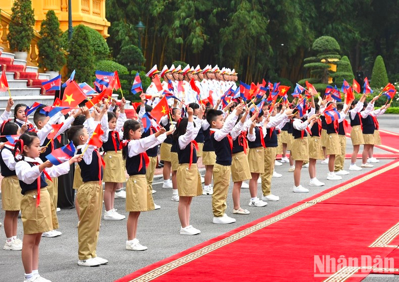 Children wave flags to the two Prime Ministers.